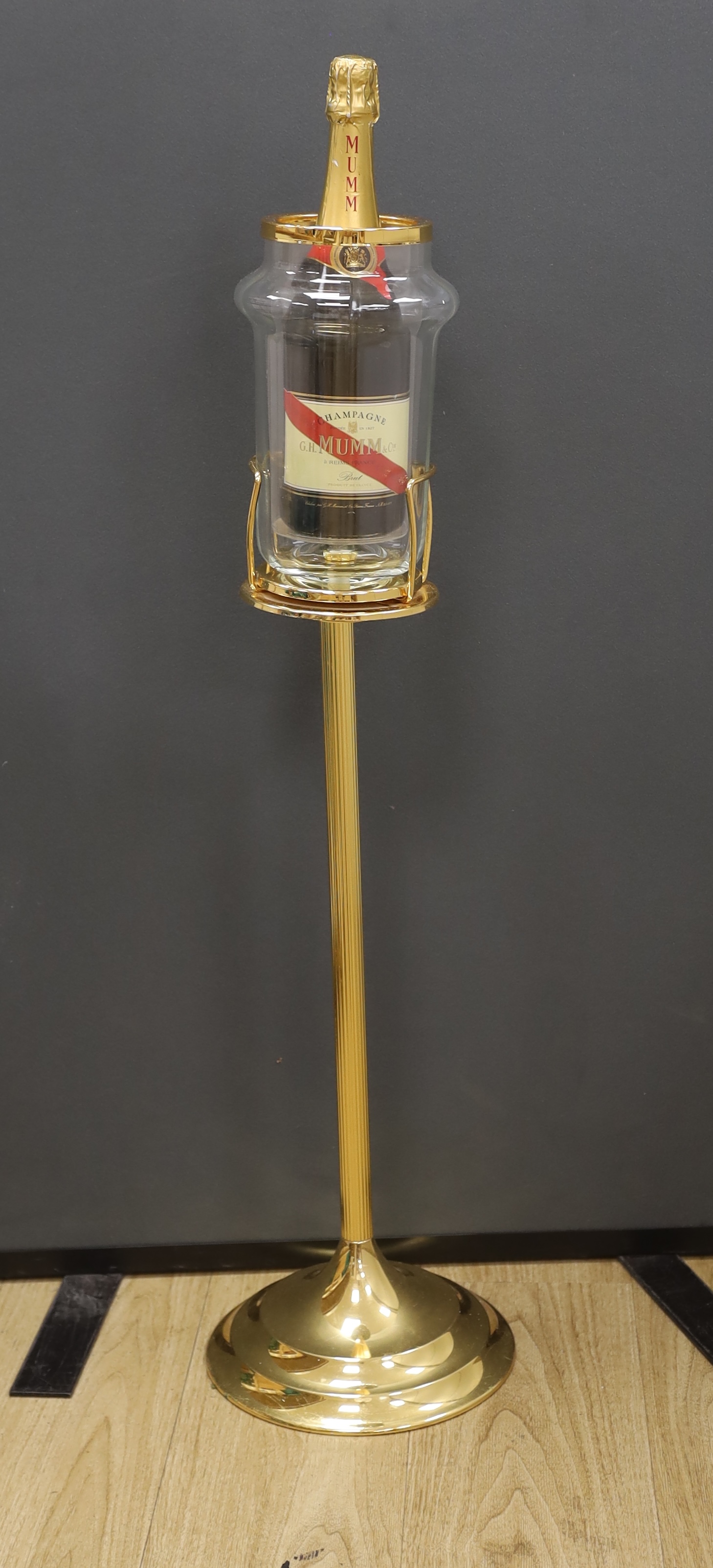 A wine cooler on pedestal, marked Faugeron, Paris, with a bottle of Mumm Champagne, 89cm high. Condition- fair, base of bottle holder needs straightening.